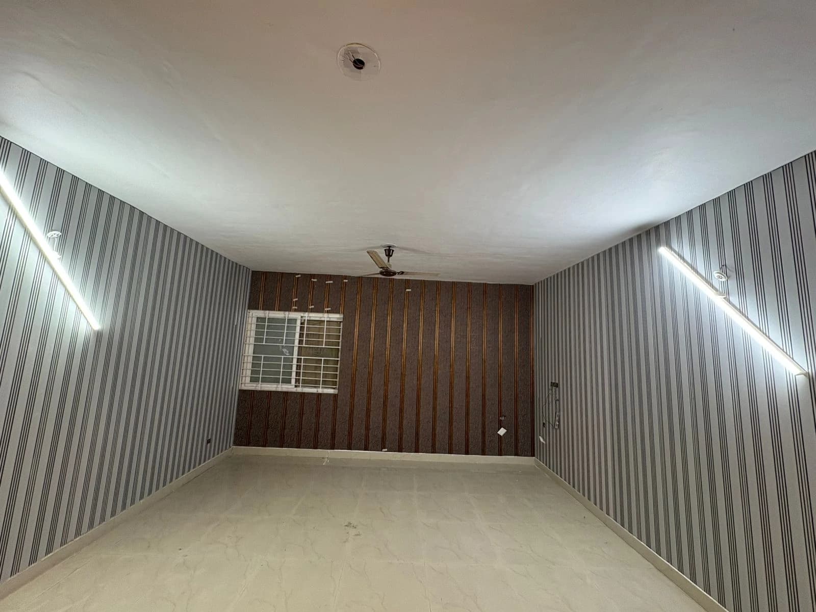 Room with LED strip lighting on walls, ceiling fan and PVC wall panels in Lucknow by Prajapati Electrical