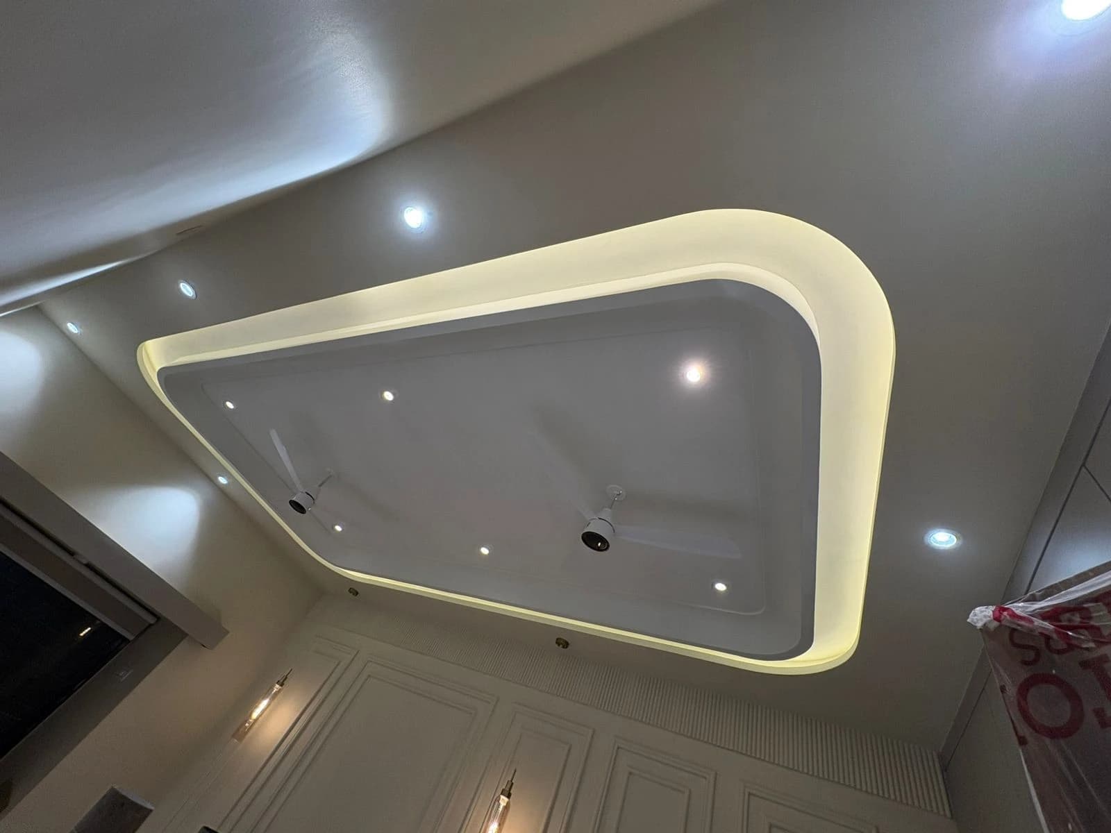 Modern false ceiling design with LED strip, recessed spot lights and ceiling fan in Lucknow by Prajapati Electrical