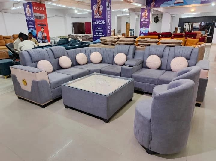 Elegant grey sofa set with round cushions and storage center table at showroom in Lucknow by Prajapati Electrical