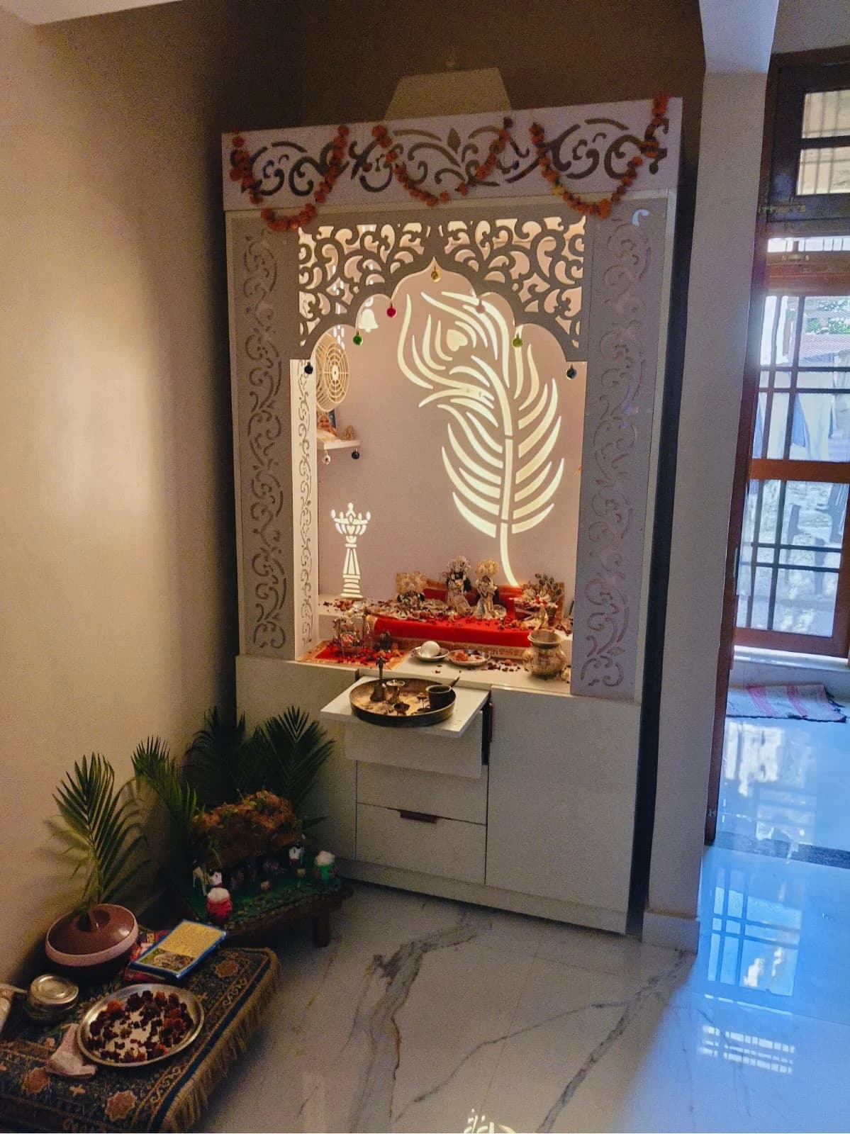 Beautiful CNC-cut designer pooja mandir with LED backlight and drawers installed at home in Lucknow by Prajapati Electrical