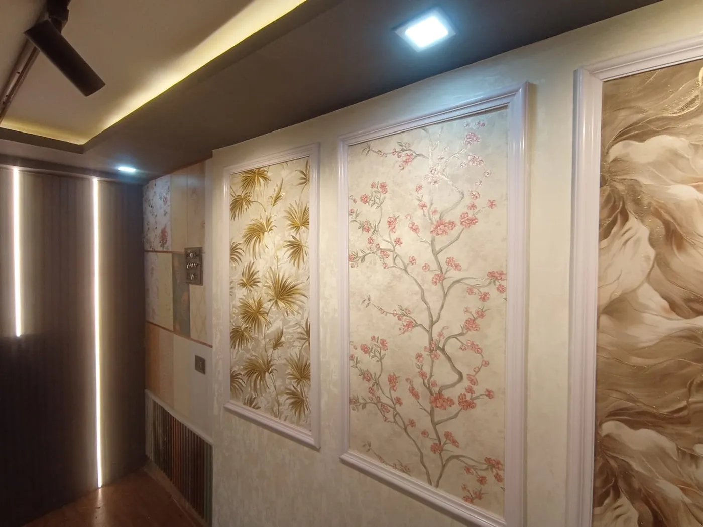 Framed decorative wallpaper panels with white moulding installed on a feature wall in Lucknow by Prajapati Electrical