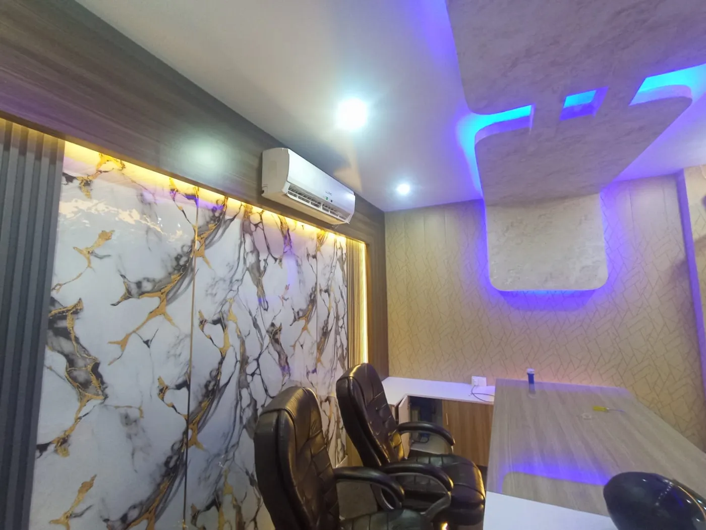 Office cabin with backlit marble feature wall, split AC and LED false ceiling in Lucknow by Prajapati Electrical