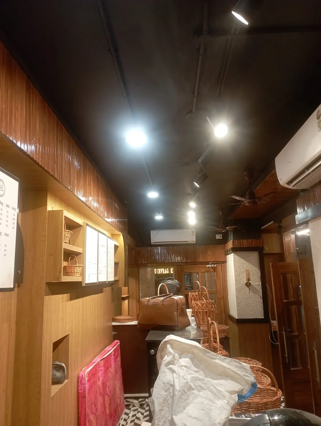 Complete juice shop interior with wooden paneling, track lights, AC and ceiling fans in Lucknow by Prajapati Electrical