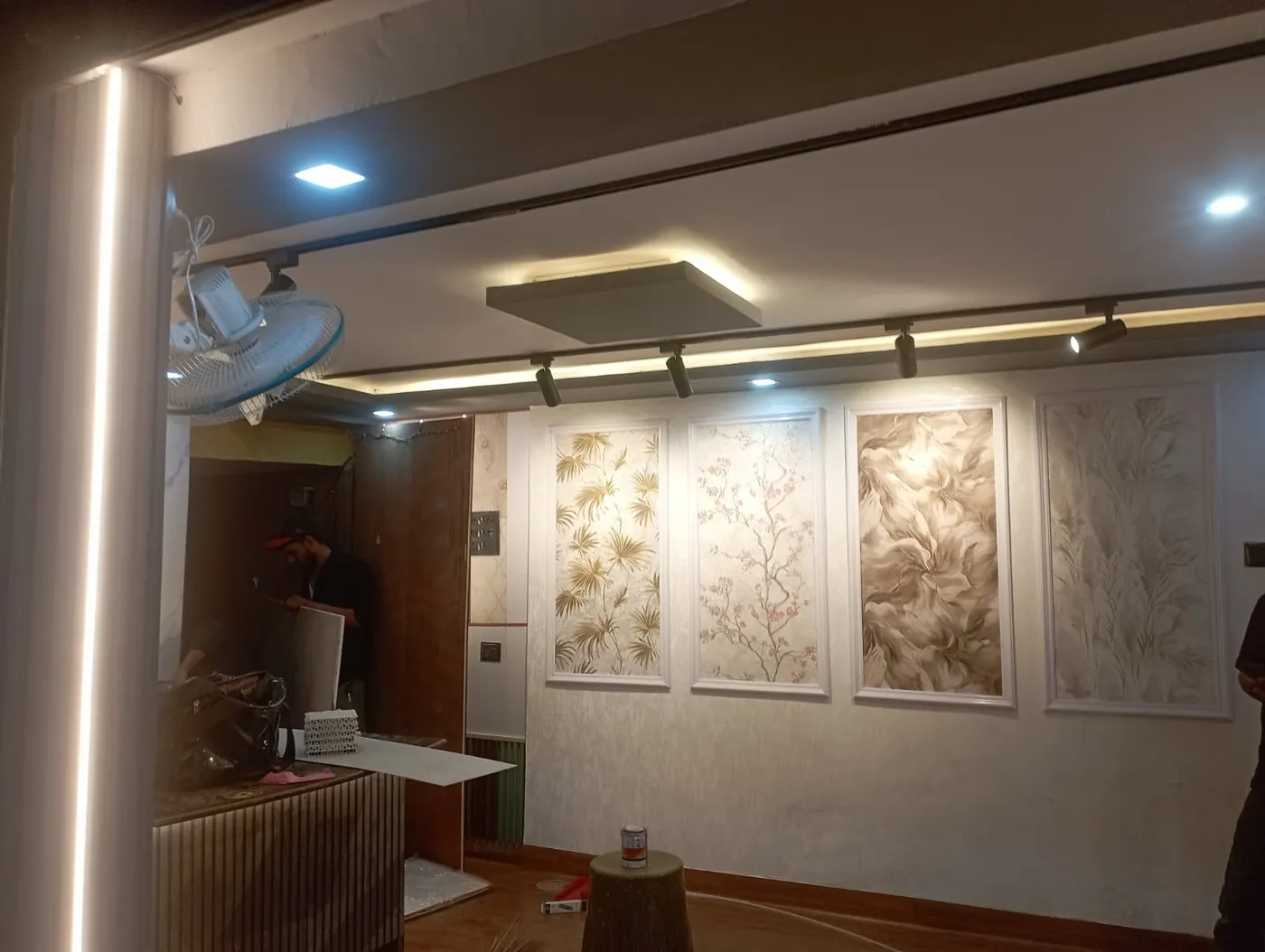 Showroom feature wall displaying framed designer wallpaper panels with track lights in Lucknow by Prajapati Electrical